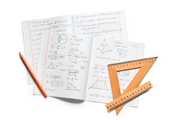 Copybook with handwritten maths formulas, pencil and rulers isolated on white background