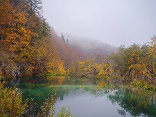 Plitvice Lakes in Croatia during autumn, showcasing stunning waterfalls, vibrant foliage, and crystal-clear waters, creating a magical and serene natural landscape. Lake fog with Autumn foliage
