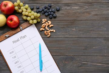 Healthy products and weekly meal plan on wooden background. Diet concept
