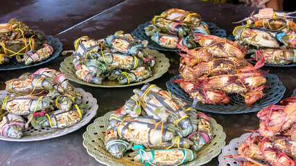 fresh alive crab being tied on its claw. fresh seafood in traditional fish market.