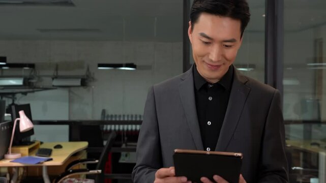Mature business man walking in office, using touchpad computer for work. Busy professional businessman going in hallway holding digital tablet thinking of work plan using tab computer