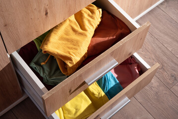 folded clothes are in the drawer of the wardrobe