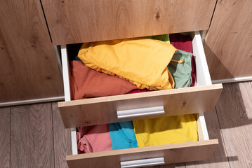 folded clothes are in the drawer of the wardrobe