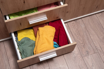 folded clothes are in the drawer of the wardrobe