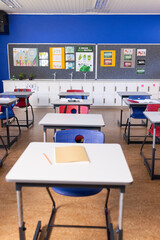 Empty classroom with desks and chairs, ready for students to arrive, copy space