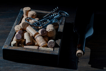 Wine corks, corkscrew and bottle on wooden table, closeup
