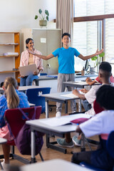 Presenting in classroom, boy engaging indian female teacher and students watching in school