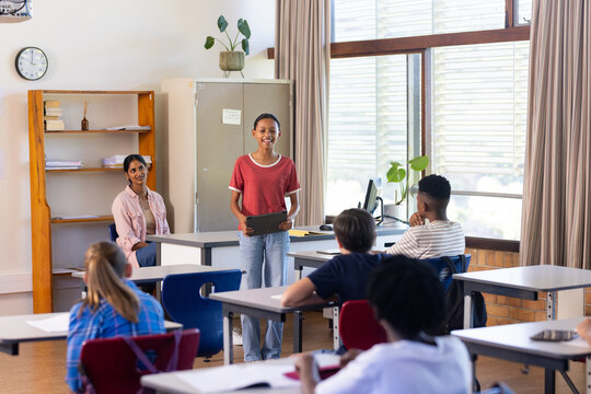 In school, student presenting project to classmates in classroom, Indian female teacher observing