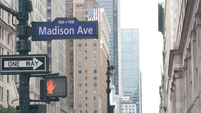 New York City crossroad, Manhattan corner, Madison avenue, street intersection road sign. Midtown district highrise architecture, United States. One way arrow roadsign, skyscrapers and traffic light.