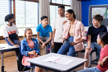 Indian female teacher engaging with students in classroom, fostering group discussion in school