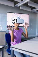 Using VR headset, student in school classroom experiencing virtual reality