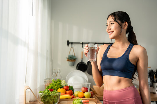 Asian beautiful woman in sportswear drink water after exercise in house. 