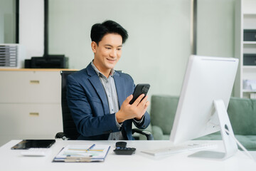 Asian businessman are delighted and happy with the work they do on their tablet, laptop and taking...