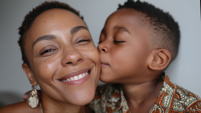 Petit gar&ccedil;on embrassant sa m&egrave;re souriante, instant complice et tendre.