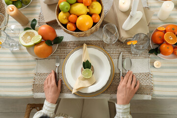 Young woman at served table prepared for dinner in room. Closeup