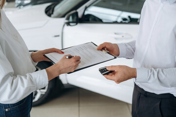 Close up view of man and woman is dealership