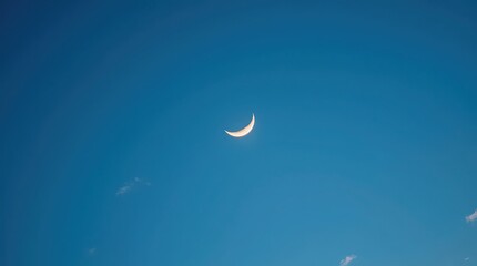 A brightly lit crescent moon, with a subtle glow on its curved edge, suspended in a