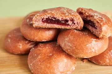Biscuits with jam filling on a wooden board, close up