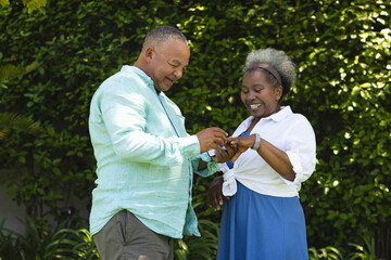 Exchanging rings outdoors, senior couple smiling and sharing special moment together