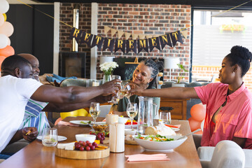 Family celebrating retirement with joyful toast around dining table at home