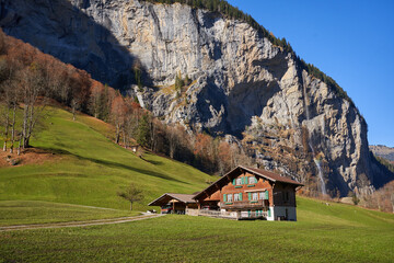 Chalet beneath alpine cliffs