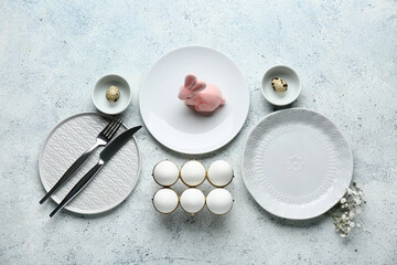 Different clean plates with Easter eggs, toy bunny and beautiful gypsophila flowers on white background