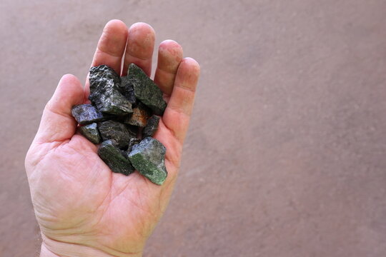 Scheelite ore held in hand. Mined for tungsten (wolfram), used to produce tungsten carbide, alloys and steels, hard permanent magnets, ammunition designed to penetrate vehicle armor in war