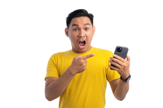 Excited handsome Asian man pointing finger at mobile phone with surprised facial expression isolated on transparent background