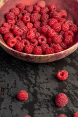 raspberries on the table, collected amount of ripe raspberries is red close up, wet slate