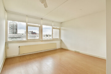 A spacious, well-lit room featuring large windows and minimal decor. The clean lines and soft colors create a tranquil atmosphere perfect for relaxation.