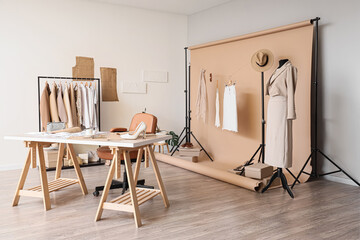 Interior of stylist's studio with workplace, clothes and mannequin