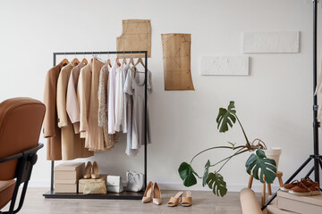 Interior of stylist's studio with clothes rack and palm plant