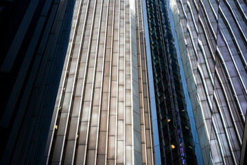 Dynamic contrast between light and shadow on skyscrapers, expressing scale, progress and financial power.