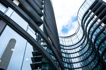 Modern business district with curved glass buildings under blue sky, symbolizing innovation, finance and corporate growth.