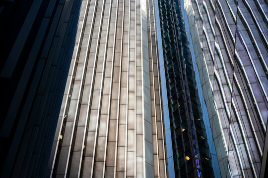 Dynamic contrast between light and shadow on skyscrapers, expressing scale, progress and financial power.