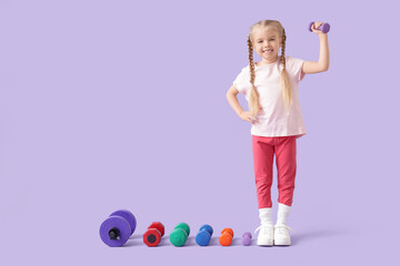 Fototapeta premium Sporty little girl with different dumbbells on lilac background