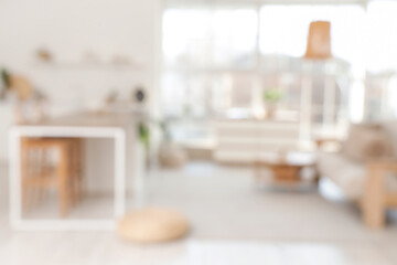 Blurred view of modern studio apartment with tables, plants and window