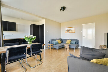 A stylish modern living space featuring a cozy seating area and an adjacent dining space. Bright and inviting atmosphere created by natural light.