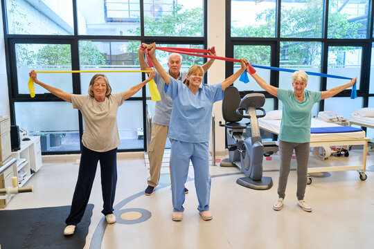 Group exercise session in senior rehabilitation facility with therapy instructor guiding participants