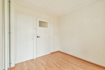 A minimalist interior of an empty room featuring plain white walls and wooden flooring, suggesting a tranquil space ready for personalization.