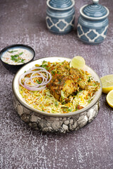 Chicken dum biryani served with a side of cooling raita and a hint of lemon zest