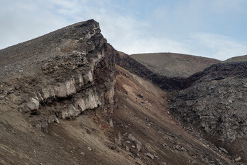 Severe mountain landscape. View of the rocky peak of the volcano. Travel and hiking on the Kamchatka Peninsula. Nature of Siberia and the Russian Far East. Gorely volcano, Kamchatka Territory, Russia.