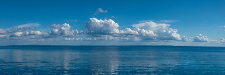 Blue sea landscape with perfectly aligned horizon with blue sky and white clouds