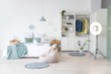 Blurred view of teenager's room with bed, ring light and closet