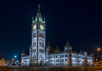 Fototapeta premium Night View of Victorian Gothic Town Hall, Illuminated Clock Tower, Historic Architecture