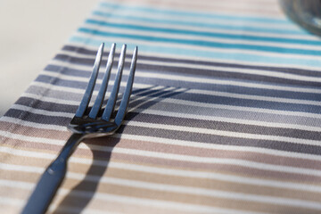 Close-up shot of a fork resting on a colorful tablecloth