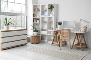 Interior of office with workplace, tulips in vase and shelf unit