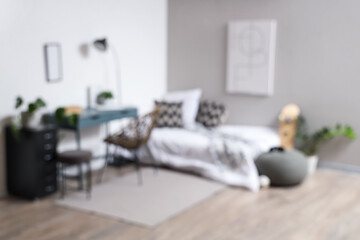 Blurred view of teenager's room with bed, workplace and lamp