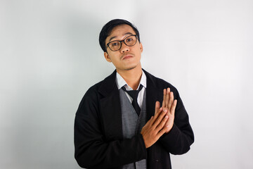 Asian man wearing a mafia-like suit and wearing glasses, with a serious face doing a clapping motion