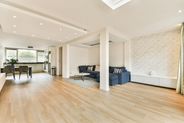 Bright and spacious living room featuring contemporary furniture, wooden flooring, and stylish decor elements, ideal for relaxation and socializing.